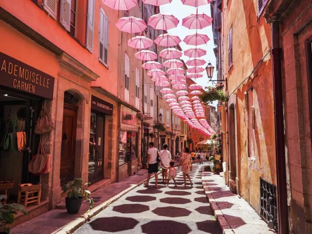 A street of pink umbrellas in the old town of Grasse